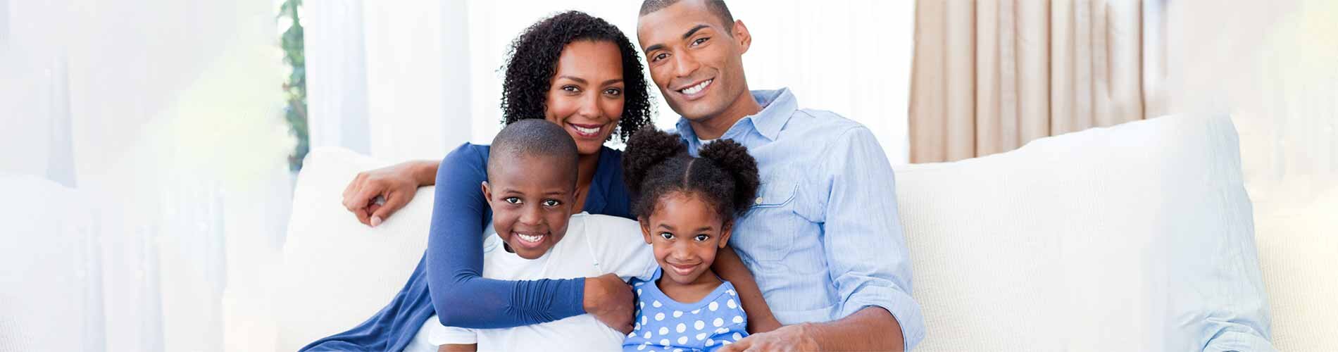 Family sitting on couch in front of window